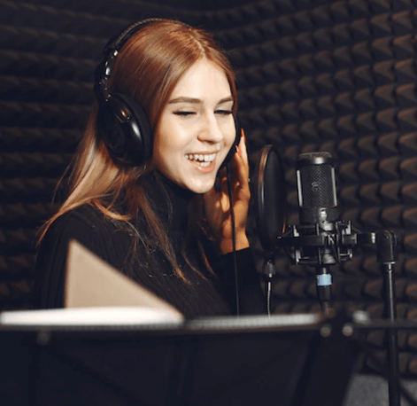 a female voice artist recording her voice in the studio