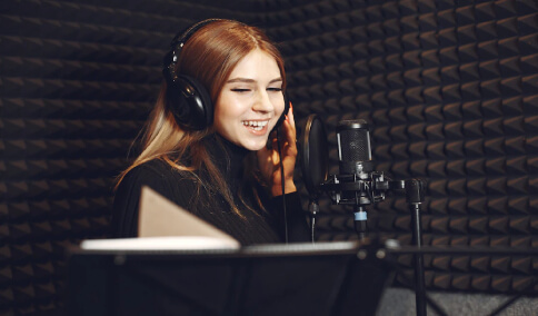 A voice over artist recording her voice in a studio