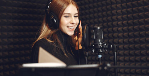 A Voice-Over Artist Recording Their Voice with Microphone in the Studio
